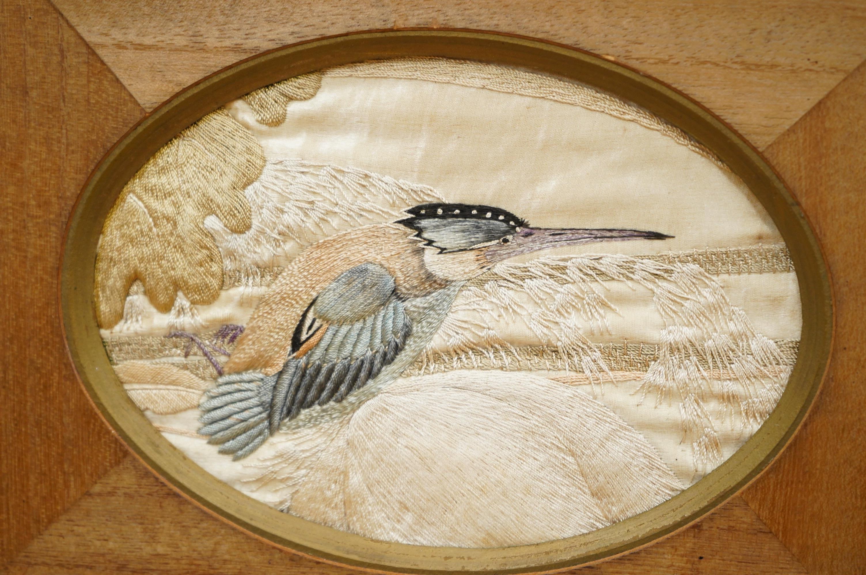 A pair of framed early 20th century Japanese oval silk embroideries of Kingfishers, embroidered on cream silk in pastel shades of silk thread, in a variety of stitches, various parts of each bird slightly couched giving